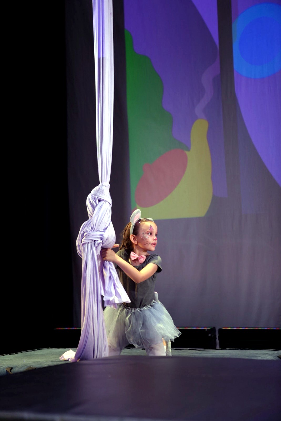 Young student climbing the silks in costume